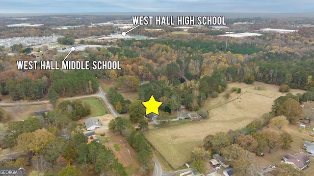 aerial view of property and surrounding area featuring a heavily wooded area