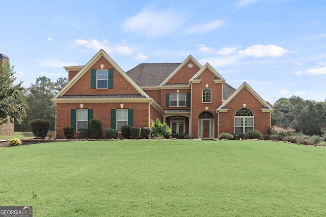 view of front of property featuring a front yard and brick siding