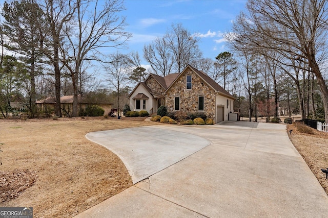 view of front of property featuring stone siding and concrete driveway