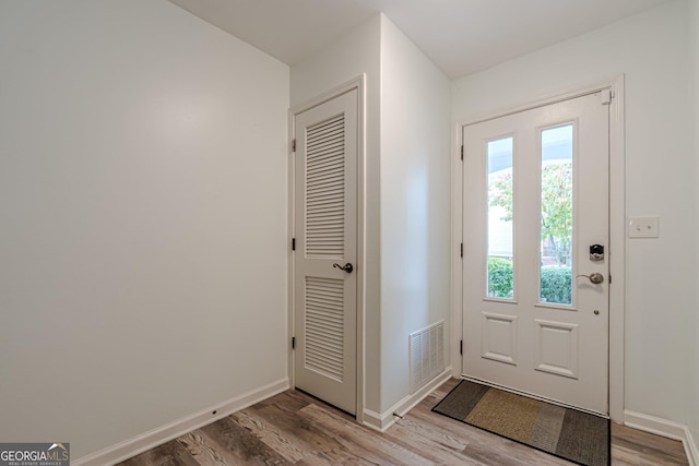 doorway to outside with visible vents, baseboards, and wood finished floors