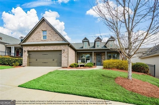 view of front of home with driveway, a garage, fence, a front lawn, and brick siding