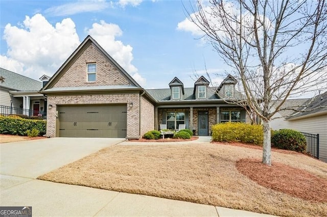 view of front of home with a garage, fence, concrete driveway, and brick siding