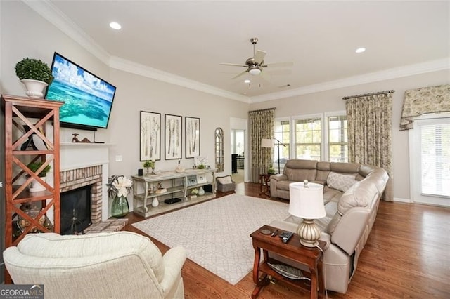 living area featuring ceiling fan, recessed lighting, a fireplace, wood finished floors, and ornamental molding