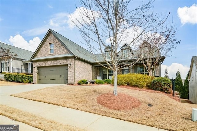 view of front of house featuring a garage, concrete driveway, and brick siding