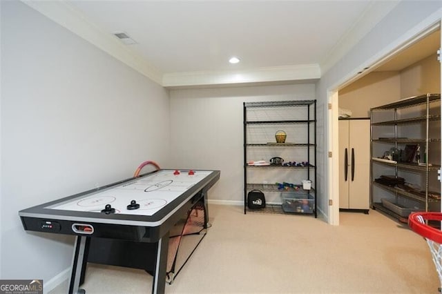 recreation room with carpet, visible vents, ornamental molding, and baseboards