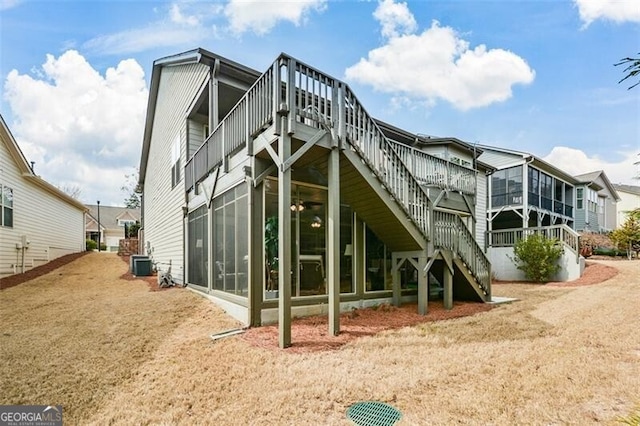 back of property with a sunroom, stairway, and central AC unit