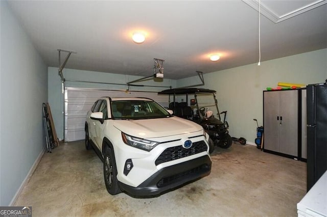 garage with freestanding refrigerator, baseboards, and a garage door opener