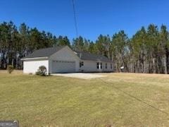 view of home's exterior with an attached garage, driveway, and a yard