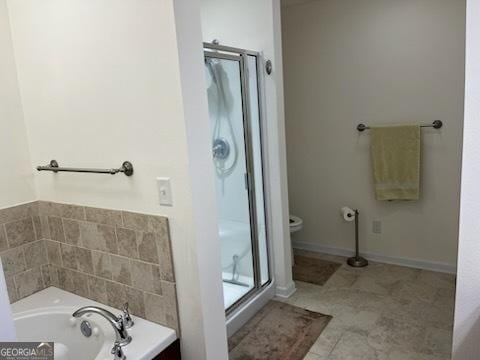 bathroom with a garden tub, a shower stall, toilet, and tile patterned floors