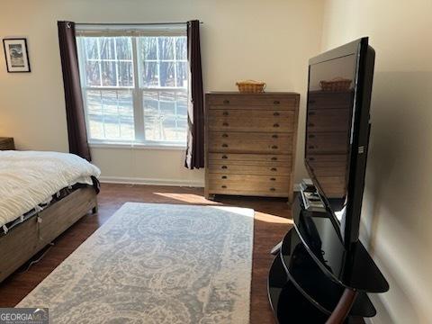 bedroom with baseboards and wood finished floors