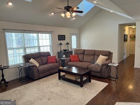 living room with a skylight, plenty of natural light, and wood finished floors