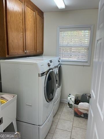 laundry room with light tile patterned floors, cabinet space, and separate washer and dryer