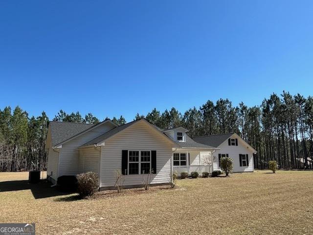 rear view of property with a yard