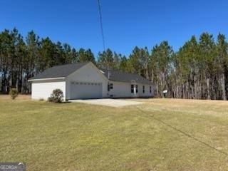 view of home's exterior with a garage, driveway, and a lawn