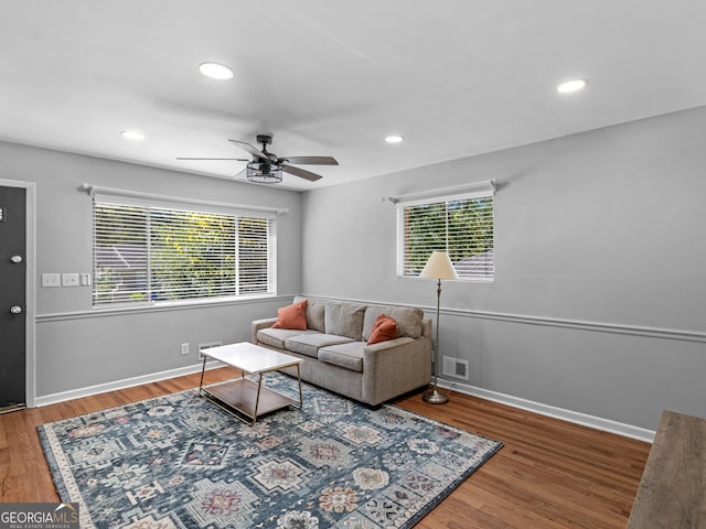 living area with a wealth of natural light, visible vents, recessed lighting, and wood finished floors