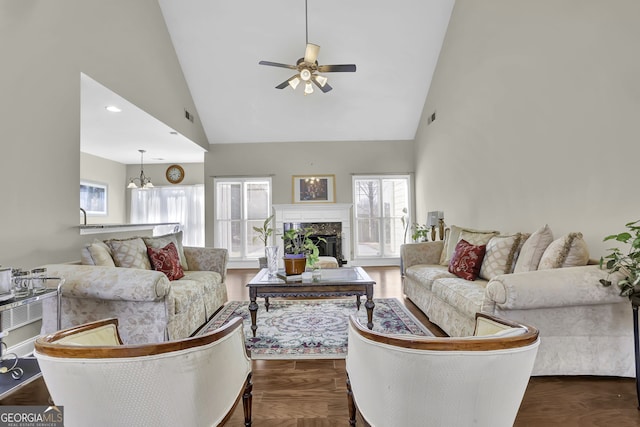 living area with high vaulted ceiling, visible vents, a fireplace, and dark wood-type flooring