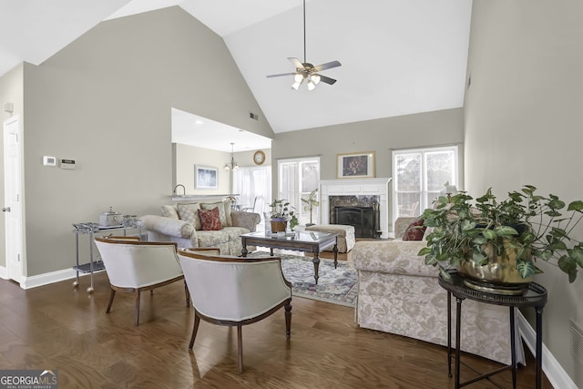 living area featuring high vaulted ceiling, dark wood-style flooring, plenty of natural light, and a fireplace