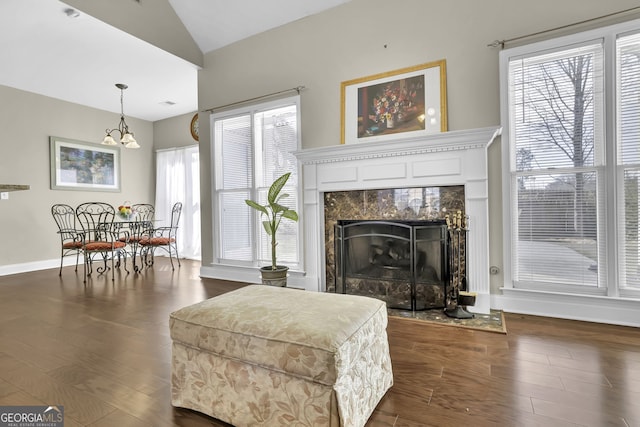 living room with lofted ceiling, dark wood-style floors, a fireplace, and baseboards