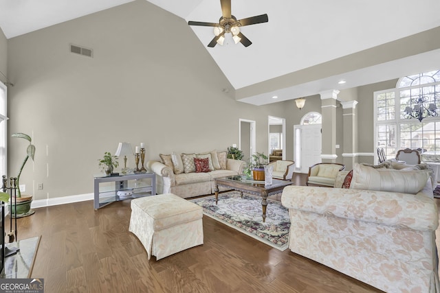 living area featuring high vaulted ceiling, decorative columns, visible vents, and wood finished floors