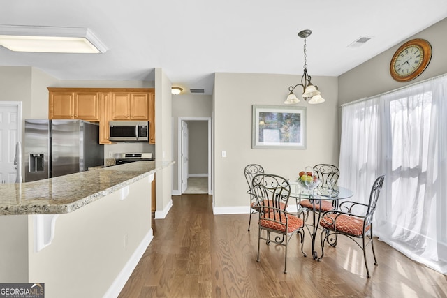 kitchen with light stone counters, dark wood-style flooring, visible vents, baseboards, and appliances with stainless steel finishes