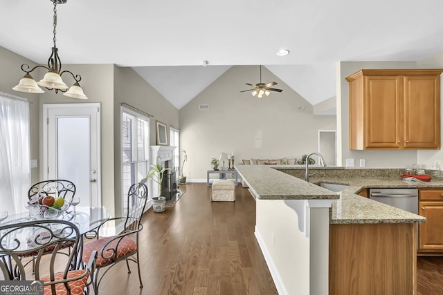 kitchen with a peninsula, dark wood-style flooring, a sink, stainless steel dishwasher, and a brick fireplace