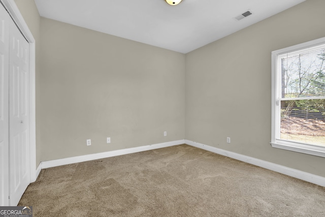 unfurnished bedroom featuring a closet, carpet, visible vents, and baseboards