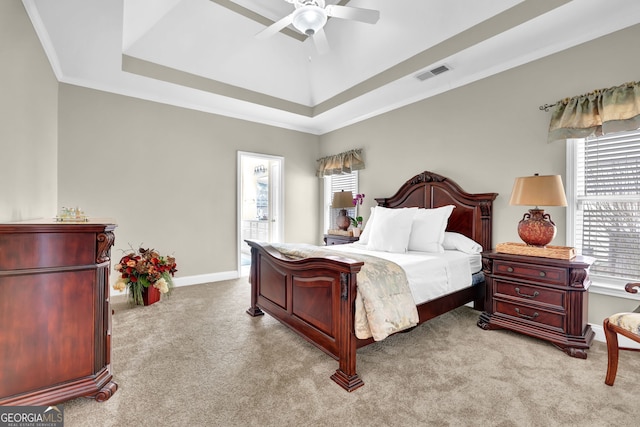 bedroom featuring carpet floors, baseboards, visible vents, and a tray ceiling