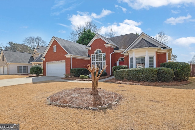 view of front of property featuring a garage, driveway, a front yard, and brick siding