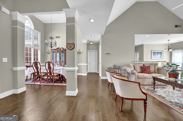 living area with a chandelier, high vaulted ceiling, visible vents, baseboards, and dark wood finished floors