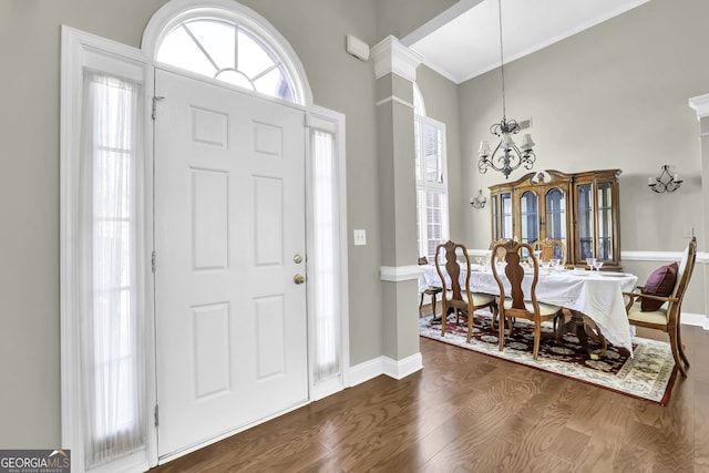 entrance foyer featuring an inviting chandelier, dark wood finished floors, a towering ceiling, and baseboards