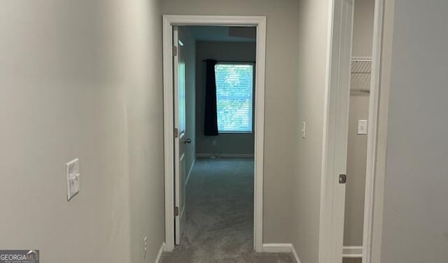 corridor with carpet and baseboards