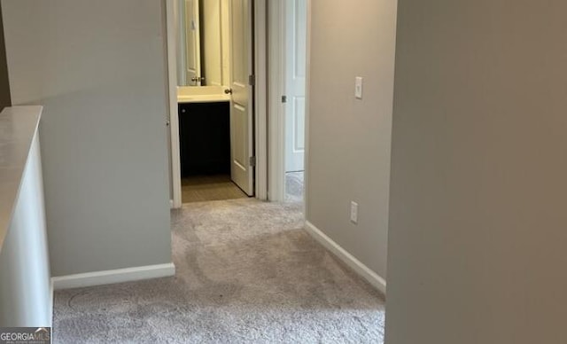 corridor featuring carpet flooring and baseboards