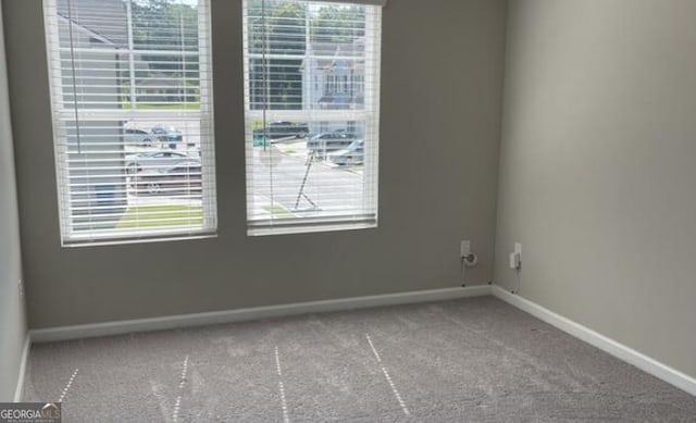 carpeted empty room featuring baseboards and a healthy amount of sunlight