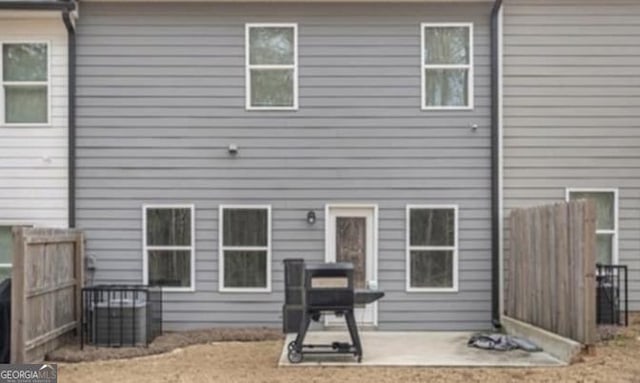 rear view of property featuring fence