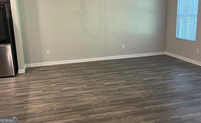 interior space featuring baseboards and dark wood finished floors