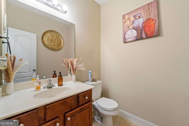 half bath featuring toilet, tile patterned floors, baseboards, and vanity