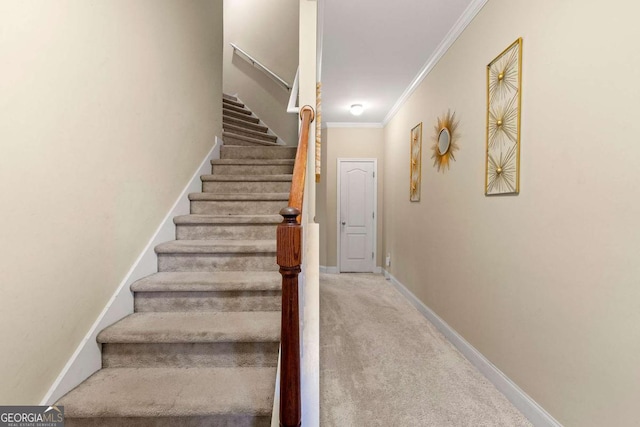 stairs with carpet floors, ornamental molding, and baseboards