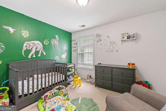 carpeted bedroom featuring a nursery area, visible vents, and baseboards