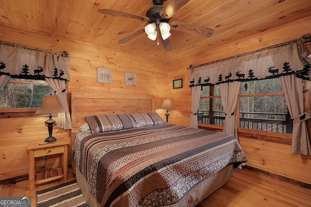 bedroom with wooden ceiling, wooden walls, and hardwood / wood-style flooring