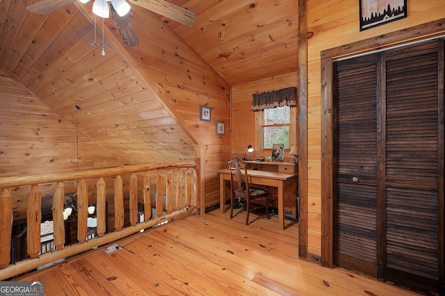 office space with vaulted ceiling, wooden walls, ceiling fan, wooden ceiling, and hardwood / wood-style floors