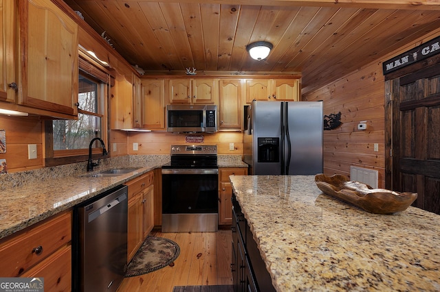 kitchen with light stone counters, light wood-style flooring, a sink, wood ceiling, and appliances with stainless steel finishes
