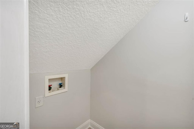 clothes washing area featuring laundry area, baseboards, washer hookup, and a textured ceiling