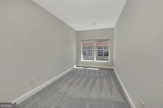 unfurnished room featuring a textured ceiling, baseboards, and carpet flooring