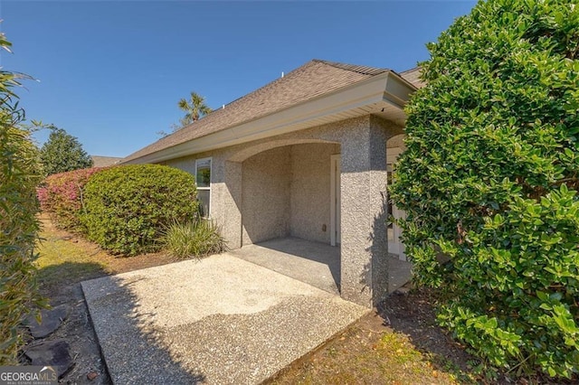 view of exterior entry with a patio area and stucco siding