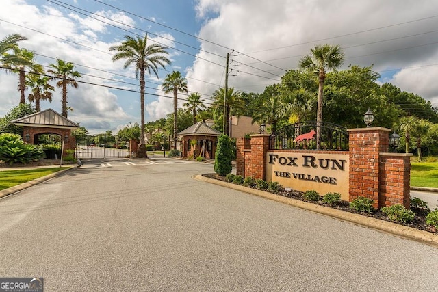 view of road with a gate, curbs, and a gated entry