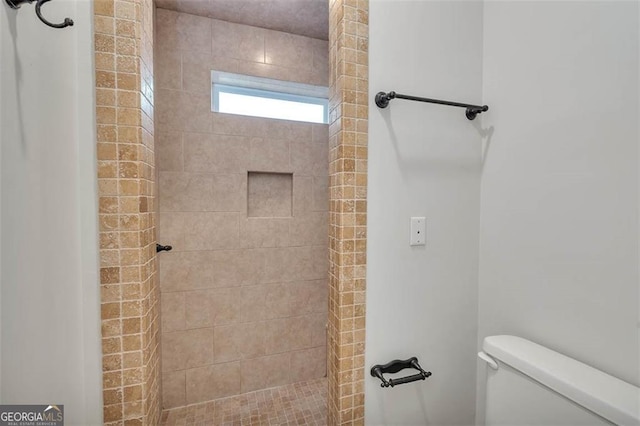 full bath featuring toilet and tiled shower