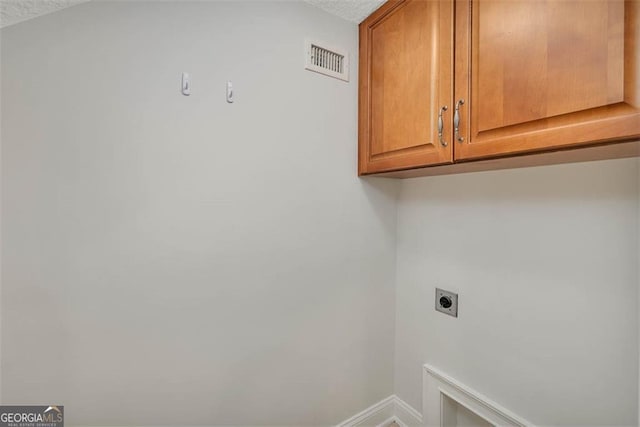 washroom with cabinet space, baseboards, visible vents, a textured ceiling, and hookup for an electric dryer