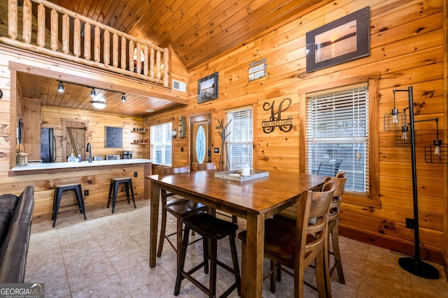 dining room with high vaulted ceiling, wooden ceiling, visible vents, and wooden walls