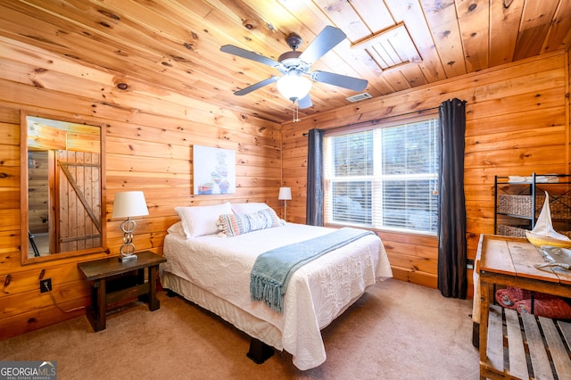 carpeted bedroom with wooden ceiling, visible vents, and wooden walls