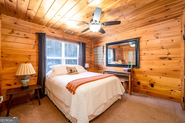 bedroom featuring visible vents, a ceiling fan, wood ceiling, light carpet, and wooden walls